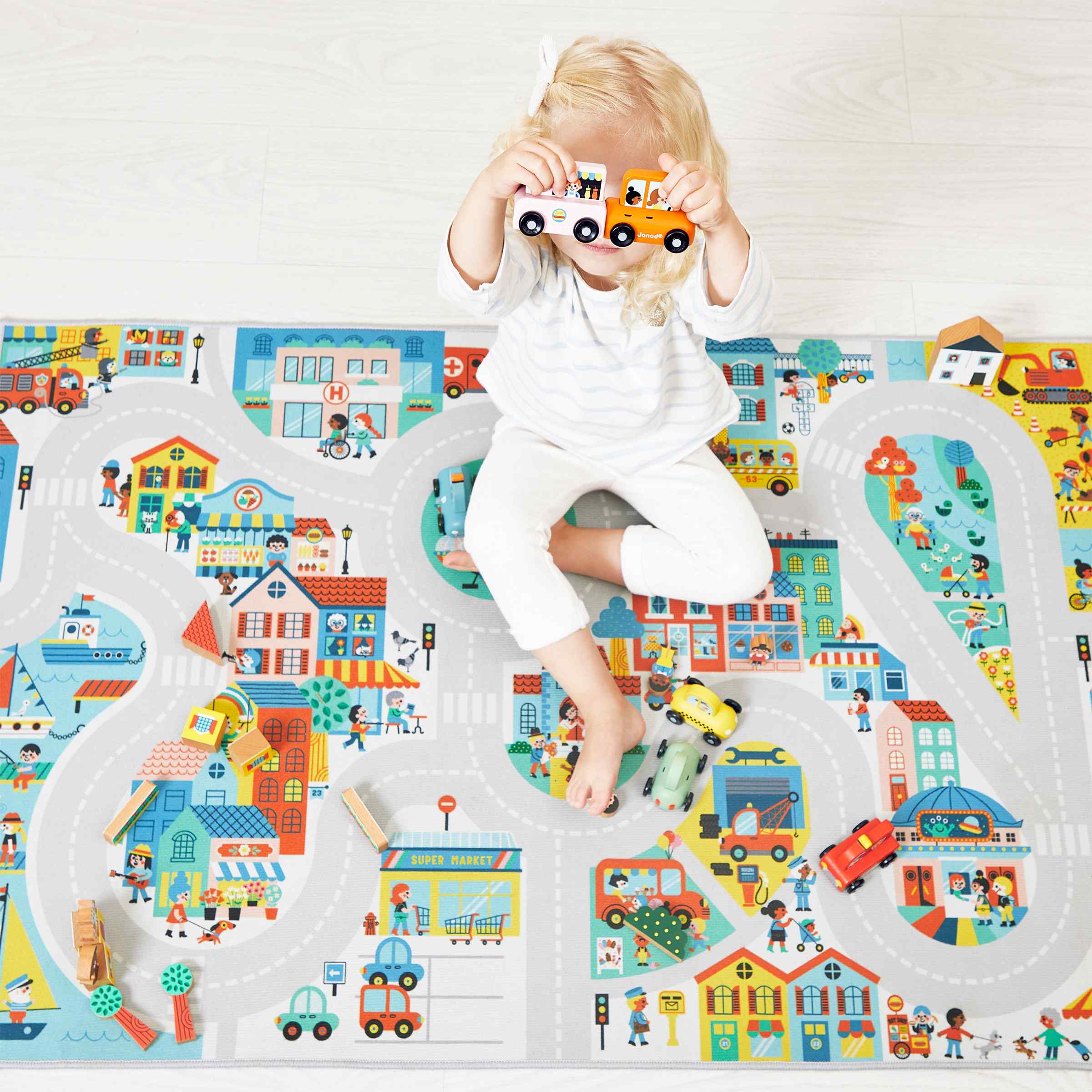 Enfant jouant sur un tapis de jeu Janod